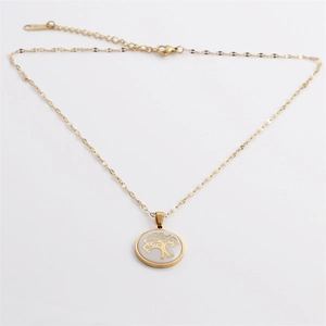 Macro view of stainless steel tree of life necklace with white shell inlay and gold plating