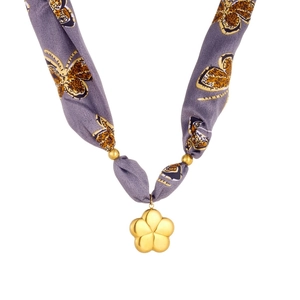 Detail of purple silk ribbon necklace with a golden flower pendant and butterfly print