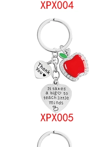 Macro shot of rhinestone apple charm and engraved metal tags for teacher gift keychain