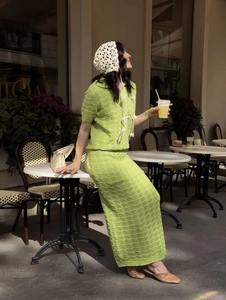 Outdoor shot of a green knit polo top and matching crochet maxi skirt set