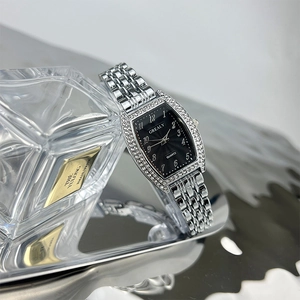 Detailed shot of tonneau emerald quartz watch with silver strap and sparkling rhinestones