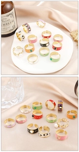 Detail of colorful enamel ring set with adjustable gold bands and diverse patterns