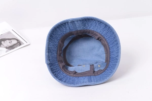 Détail de l'intérieur d'un bob en jean délavé avec bandeau et coutures renforcées