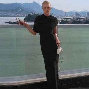 Détail d'une robe noire élégante à épaule dénudée avec tissu froncé et coupe ajustée