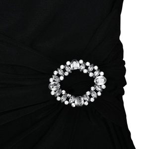 Detail of waist rhinestone buckle on a black slim fit dress with pleated fabric texture