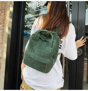 Detailstruktur des grünen Cord-Rucksacks mit Vordertasche und Metall-Reißverschluss-Qualität