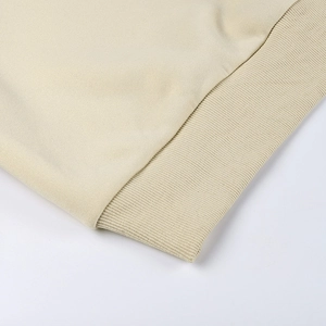 Gros plan sur les poignets côtelés et l'ourlet d'un sweat-shirt beige à manches longues