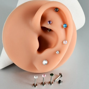 Macro detail of G23 titanium labret studs with multi-color zircon and internal threads