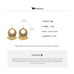 Detailed view of vintage gold hollow round drop earrings with floral enamel and beaded fringe