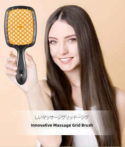 Detail der hohlen Haarbürste mit schwarzem Griff und gelben Massageborsten auf Modell