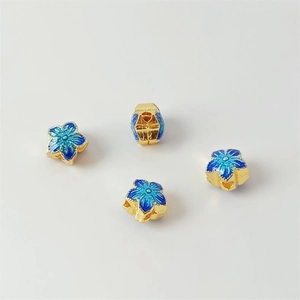 Macro shot of 18K gold-plated blue cloisonne flower spacer beads for DIY jewelry