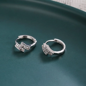 Macro shot of silver-colored round earrings with double-row sparkling cubic zirconia
