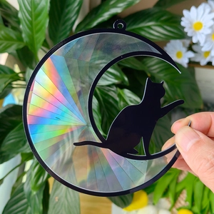 Close-up of holographic acrylic moon suncatcher featuring a black cat silhouette