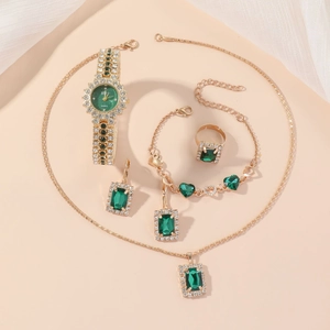 Golden watch and emerald jewelry set with necklace, bracelet, ring and earrings