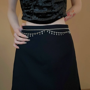 Detail of double-layer silver waist chain with shimmering rhinestone fringe on a black skirt