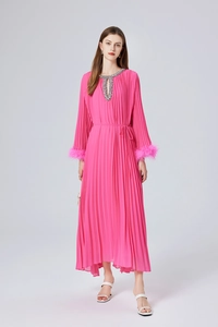 Détail de la robe plissée rose fuchsia avec poignets en plumes et col en cristal