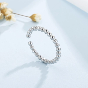 Vue détaillée d'une bague à perles argentées avec finition polie et décor de fleurs séchées