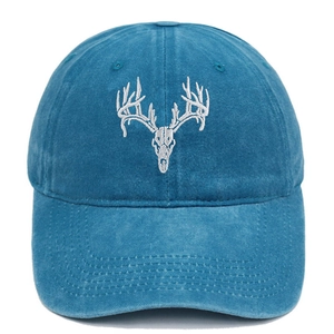 Close-up of a washed blue cotton baseball cap featuring white elk skull embroidery