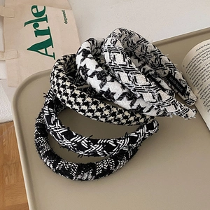 Detail showing various black and white knitted plaid headbands with hand made label