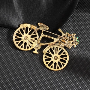 Vintage gold bicycle brooch with rhinestones, elegant accessory for suits and jackets