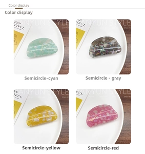 Detail view of colorful faux acetate hair claws in teal, grey, yellow, and red colors
