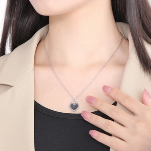 Close-up of a silver heart-shaped lock pendant necklace worn on a female model
