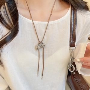 Macro shot of silver dual heart pendant with cubic zirconia and brown woven bolo tie