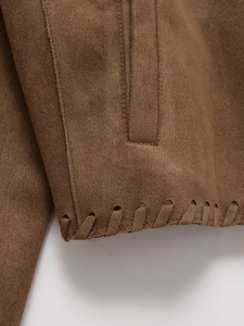 Détails de la veste en daim marron avec coutures décoratives croisées et laçage élégant