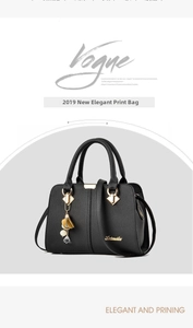 Détail du sac à main noir à grain litchi avec finitions métalliques dorées et accessoires
