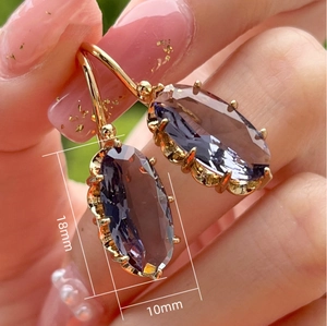 Macro view of gold drop earrings with oval purple stones and 18mm length detail