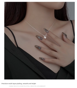 Close-up of S925 silver bow heart necklace featuring sparkling diamonds on an elegant neckline