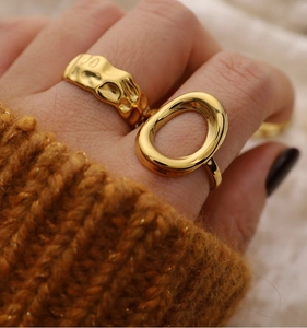 Detail of hand wearing 18K gold plated stainless steel hammer and oval cutout rings