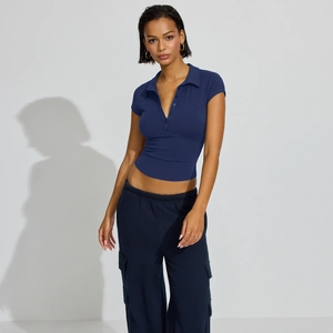 Detail of navy blue slim fit polo knit top with button neckline and ribbed texture
