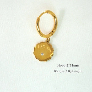 Macro shot of 14K gold petal pendant with I love you engraving and clear gem