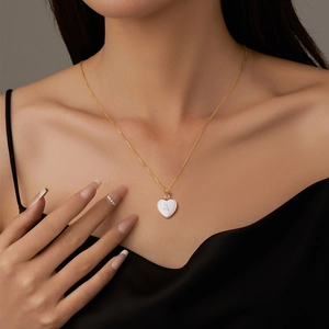 Close-up of a white marble heart pendant with gold plating on a delicate chain necklace