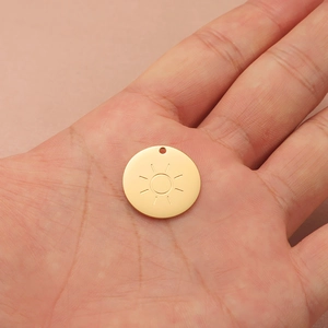 Minimalistische gouden zonnehanger van roestvrij staal gepresenteerd op een handpalm