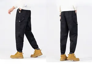 Detail view of black camouflage cargo pants with side flap pockets and cuffed ankles