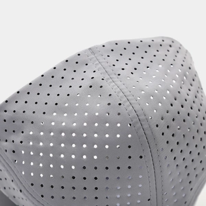 Close-up of laser-cut ventilation holes and reinforced stitching on gray sports cap