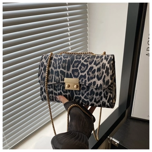 Detail of leopard print handbag with golden chain strap and metallic lock closure