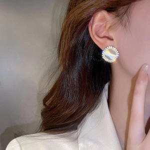 Elegant gold-plated square cat eye stone earrings with zircon halo worn by a model