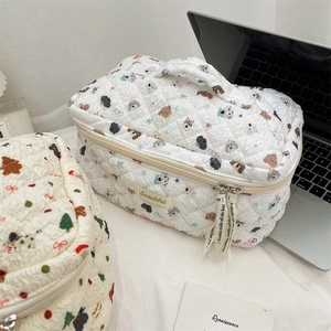Detail of white quilted cosmetic bag with cute cartoon dog patterns and sturdy top handle