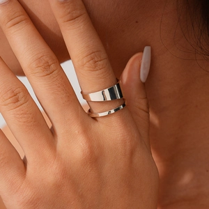 Macro shot of a minimalist double-layer silver wrap ring on a model's finger