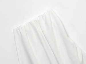 Detailed view of elastic waistband and pleated fabric texture on white pants