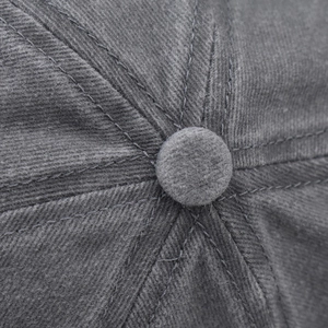 Close-up of the washed cotton twill crown and top button of the dark gray baseball cap