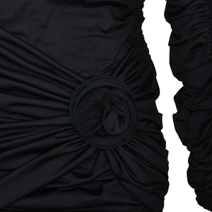 Détail du plissage élégant et de la rose en relief sur la robe moulante noire sophistiquée