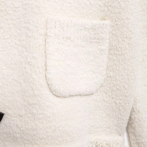 Elegant white tweed knit cardigan with fringe details and fluffy texture close-up view