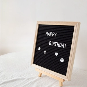 Detail of wooden felt letter board with white characters and a small wood tripod stand