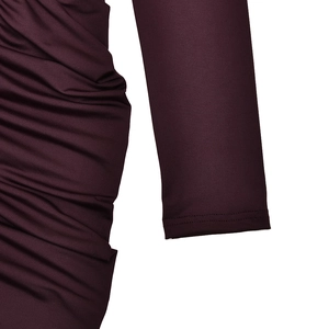 Detail of deep purple long sleeve dress featuring ruched elastic knit fabric texture