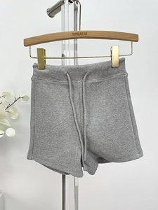 Close-up of light gray knit sports shorts showing elastic drawstring waist and soft texture