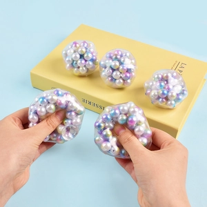 Close-up of 5 colorful decompression squeeze balls filled with vibrant pearl beads